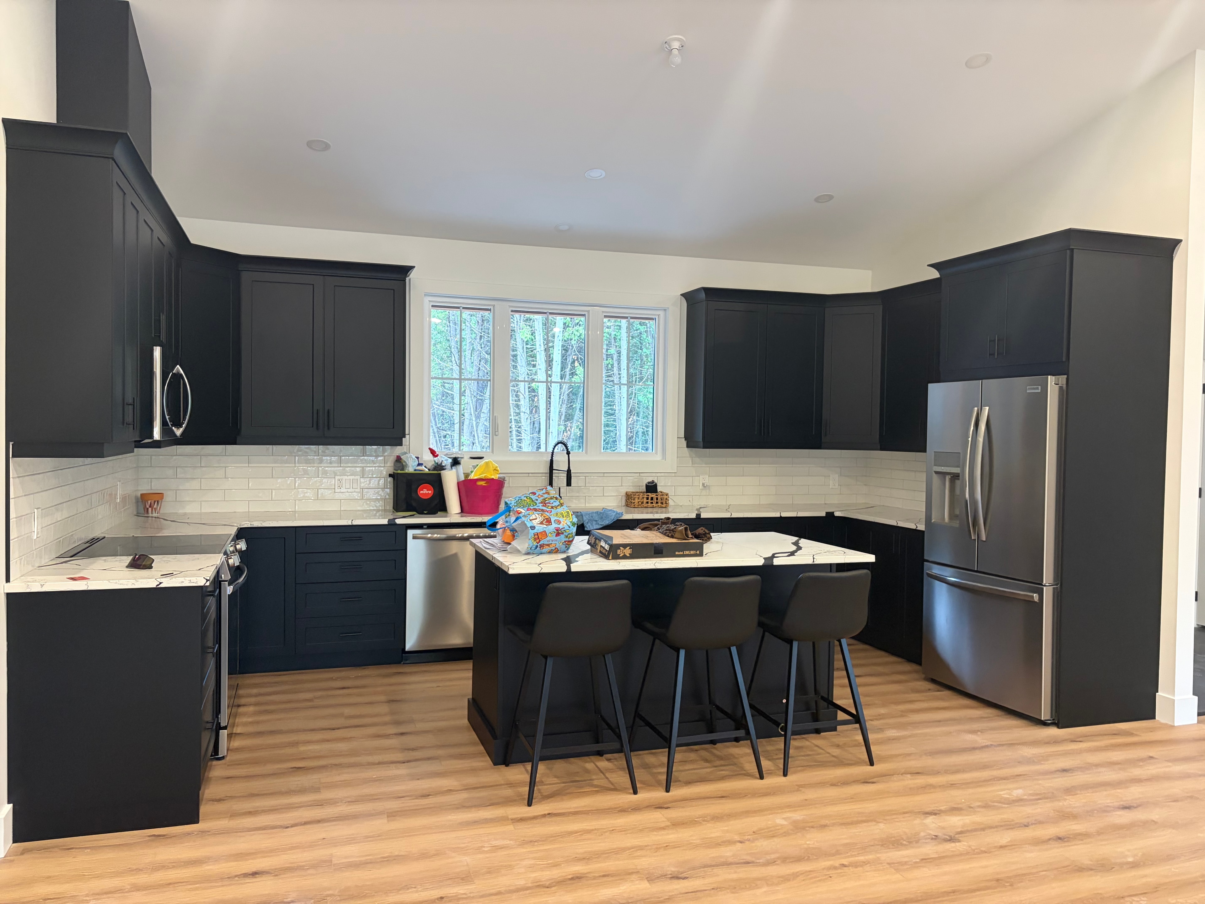 Modern kitchen with black cabinets and marble island