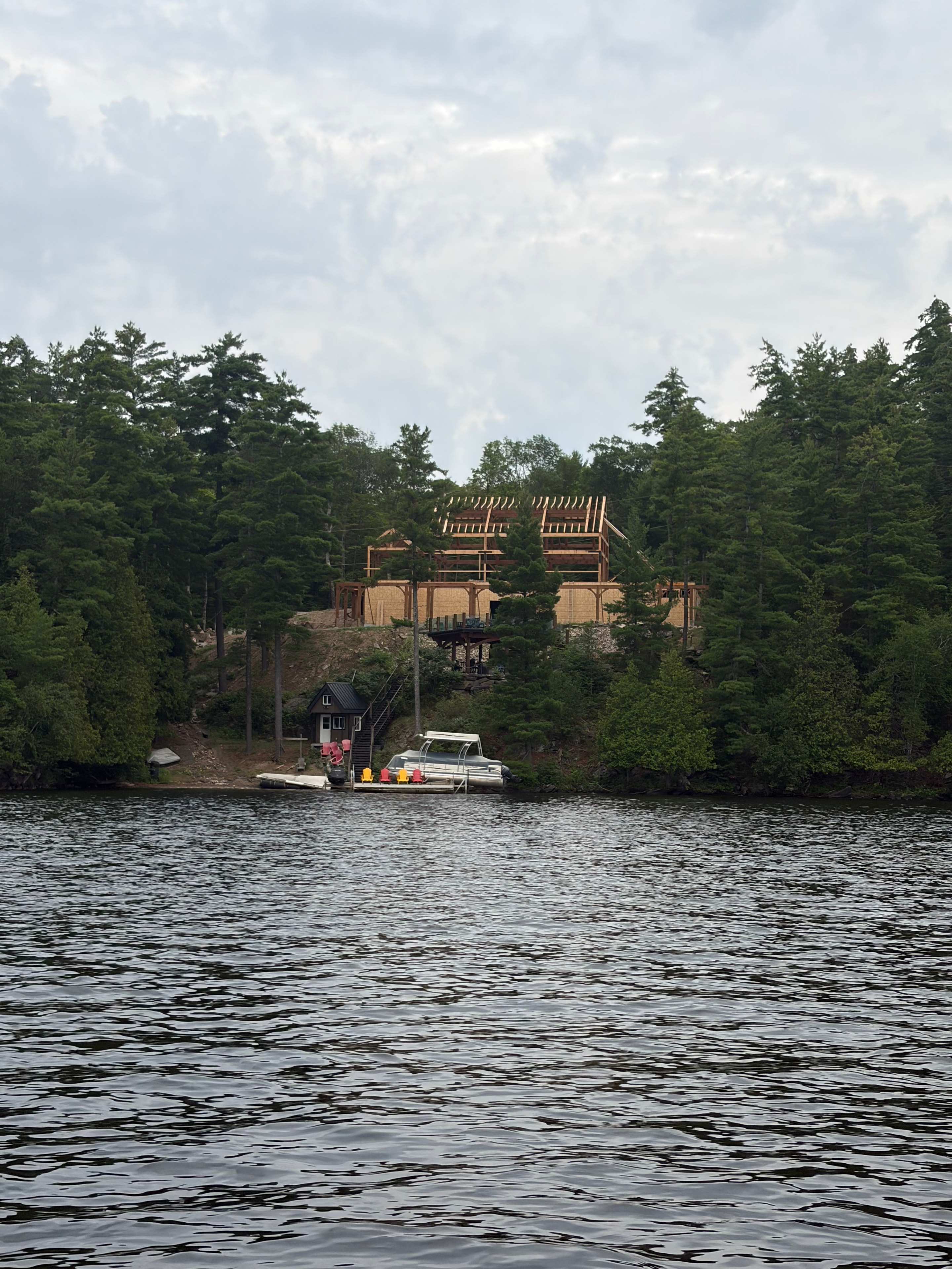 Lakeside home framing under construction viewed from the water